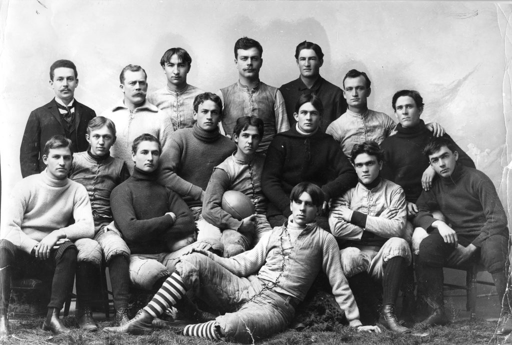 Group of young men in a classic photo, holding a football