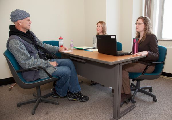 Two volunteers offer legal advice to a veteran.