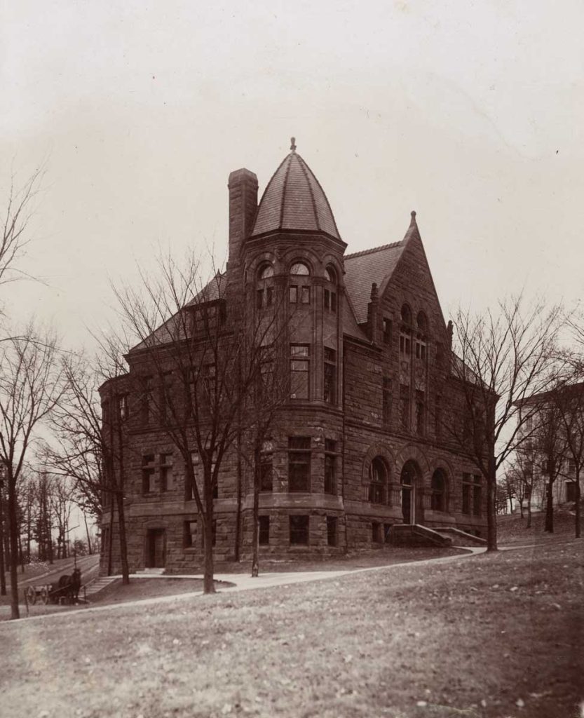 A stone building with an arched dome on top of a corner tower.