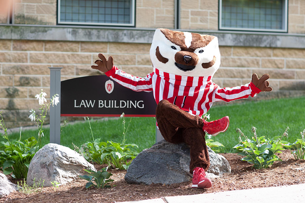Bucky Badger sits in front of Law Building sign