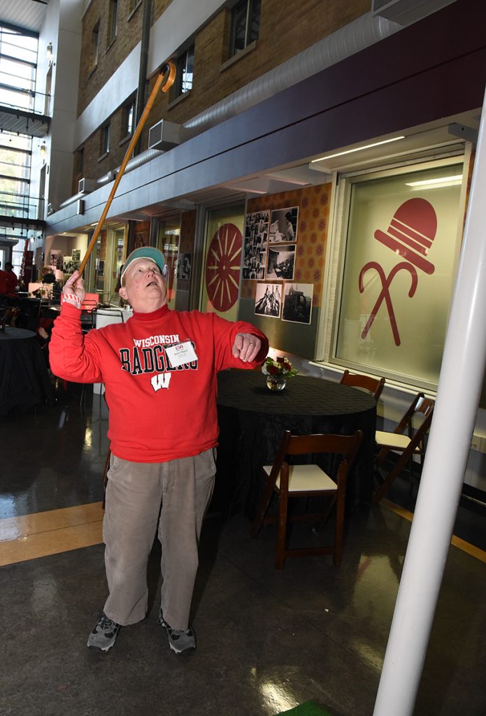 Alumnus throws cane over cane toss display